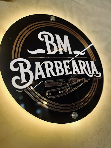 Logo BM Barbearia iluminada na parede